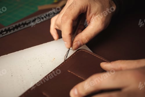 Preview: tanner makes genuine leather wallet, professional craftsman, closeup, indoor, authentic, business