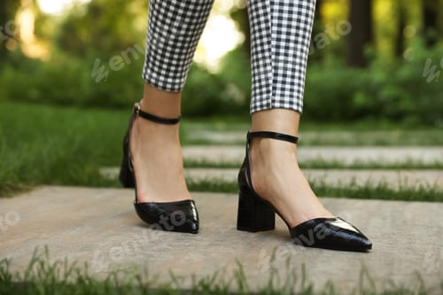 Preview: Woman in stylish black shoes walking at park, closeup