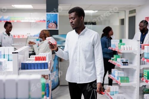 Preview: African american man buying heart supplements in drugstore