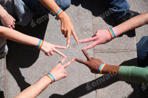 Preview: Activists wearing rainbow bracelets forming star with fingers