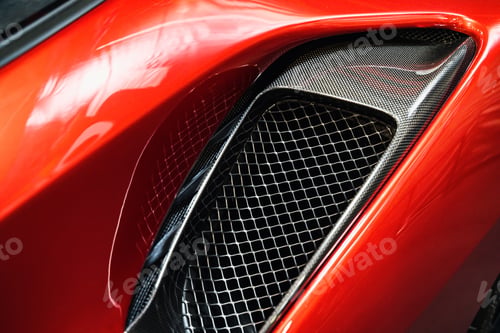 Preview: detail of sport car with red metal hood and black air flow intake ornament