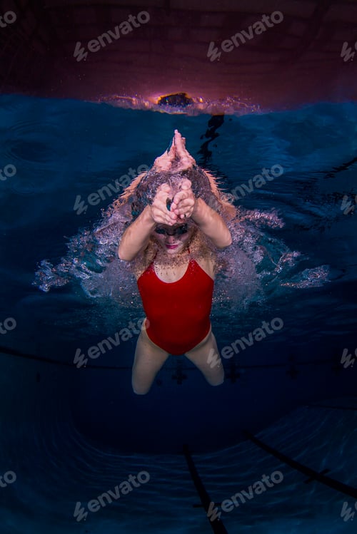 Preview: Young woman swimming underwater