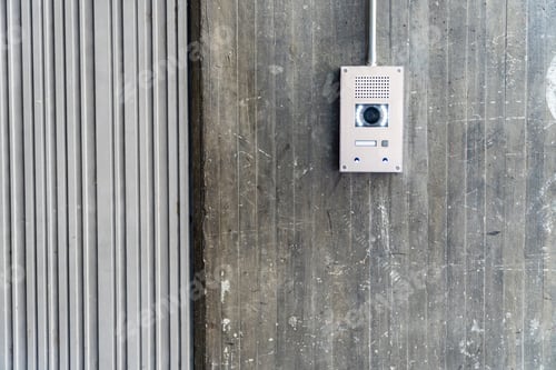 Preview: real photography of an intercom with surveillance camera on a textured concrete wall