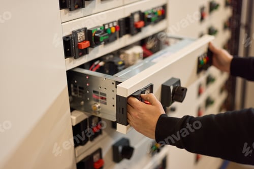 Preview: Technician Adjusting Components in an Electrical Control Panel for Maintenance