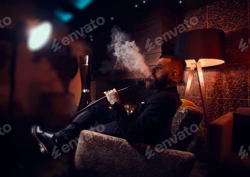 Preview: Bearded Man Smoking Hookah Indoors at Night