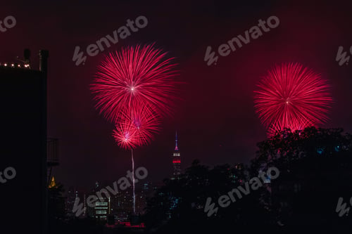 City Skyline at Night with Red Fireworks Display