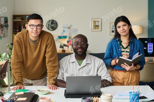 Visualização: Adultos multiétnicos colaborando em torno de um laptop em um escritório criativo