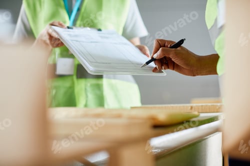 Preview: Close-up of warehouse supervisor signing paperwork at distribution compartment.