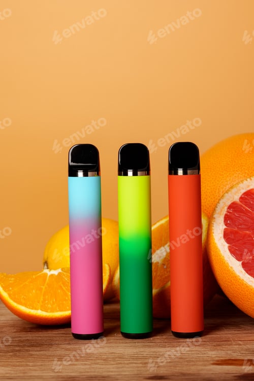 Preview: Three electronic cigarettes with citrus fruits on orange background