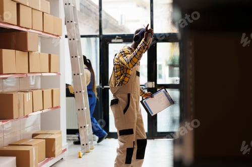 Preview: Happy african american shipment manager enjoying work in warehouse