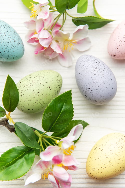 Preview: Easter eggs and spring flowers creating a festive decoration on white wooden background