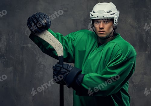 Preview: Hockey player wearing black protective uniform holds a hockey stick on a gray background.