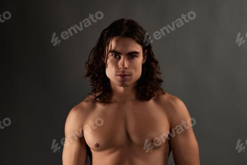 Preview: Handsome Man With Wavy Hair Posing in Front of Grey Background