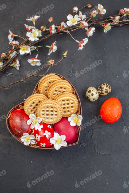 Preview: top view colored easter eggs with cookies inside heart shaped box on dark surface ornate spring
