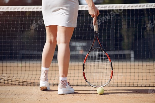 Preview: Cropped photo of legs of female tennis player who holding a racket