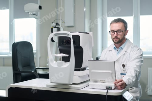 Preview: Middle Aged Man Operating Ophthalmology Equipment in Clinic