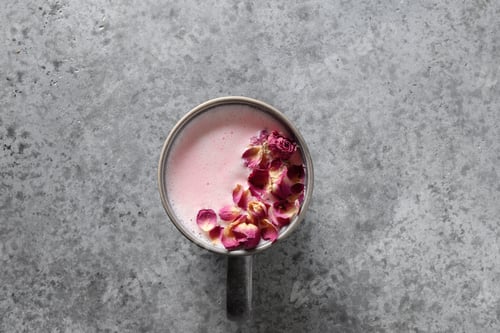 Preview: One cup of rose moon milk on grey background. Top view. Copy space.