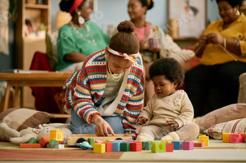 Preview: Black Girl Helping Younger Sister Playing with Toys on Floor at Home