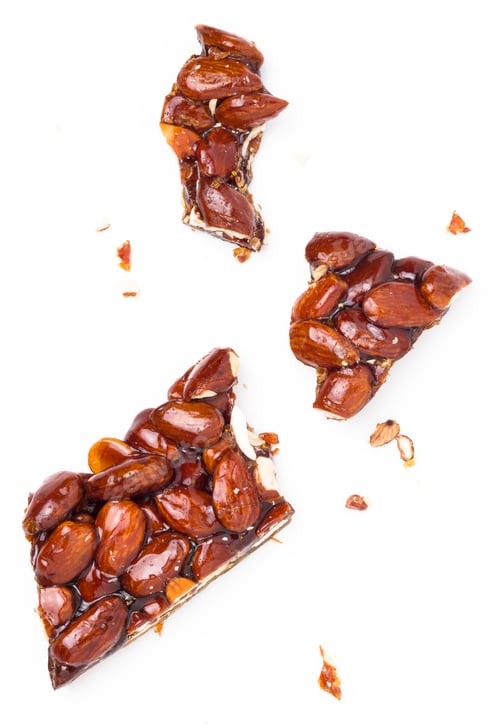 Almond brittle pieces on white background