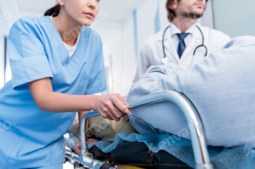 Preview: Cropped view of doctors in uniform transporting patient