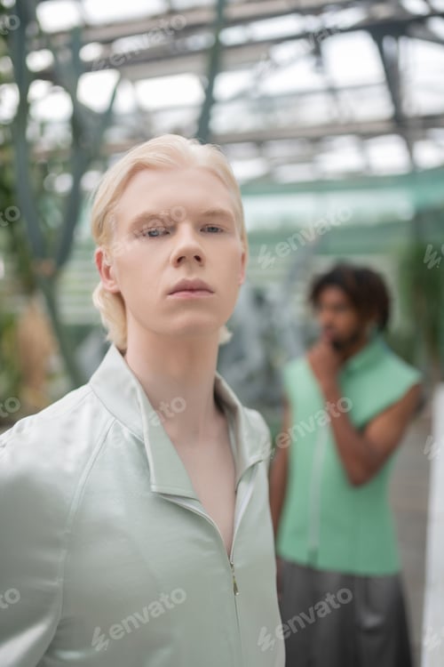 Preview: Blonde-haired male model posing in greenhouse with colleague
