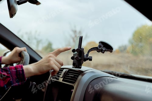 Preview: car driver hand point finger using smartphone application with map navigator to find the way f