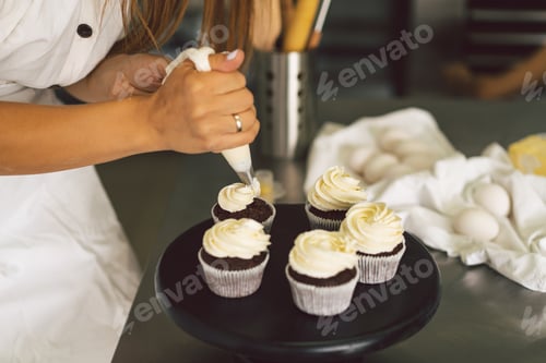 Vista previa: La pastelera está preparando unos cupcakes. Concepto: ingredientes para cocinar productos de harina o postres