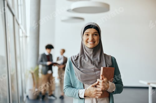 Preview: Portrait of happy Muslim businesswoman at corporate office looking at camera.