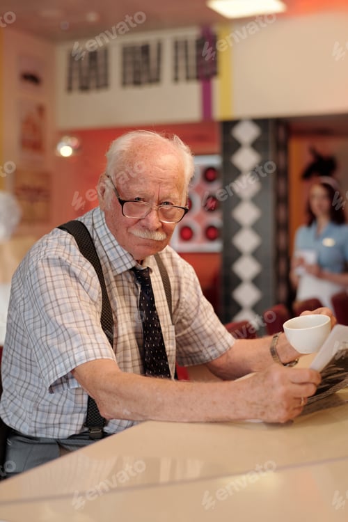 Preview: Engaging Elderly Man Enjoying Coffee at Cozy Cafe Counter