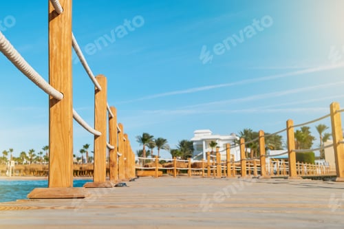 Preview: Wooden pier on sea stretching into distance beyond horizon on sunny summer day. Vacation and Travel