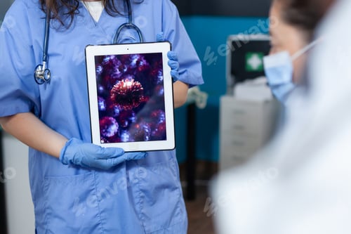 Preview: Closeup of practitioner woman nurse holding tablet computer with virus expertise