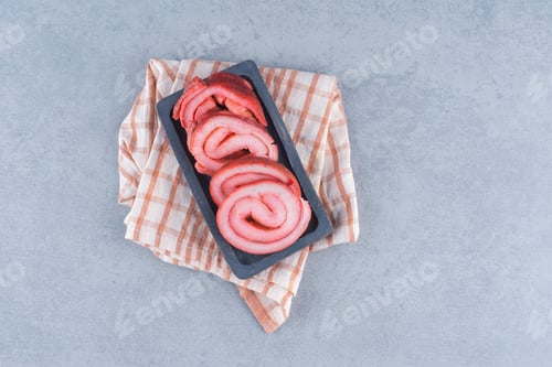 Preview: Fried bacons in black plate on grey background