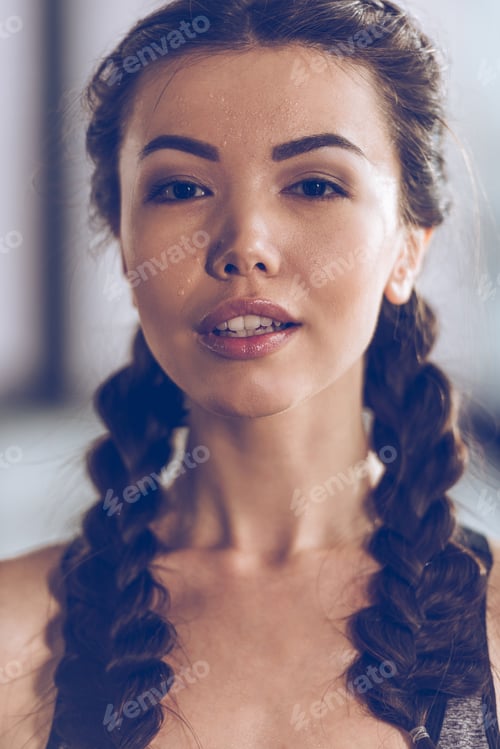Preview: Close-up portrait of beautiful young sporty woman looking at camera