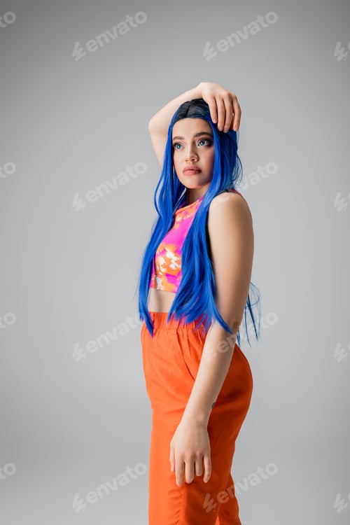 Preview: youthful energy, tattooed young woman with blue hair posing in colorful clothes
