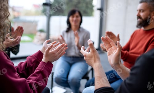 Preview: Men and women sitting in circle during group therapy, clapping