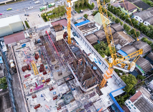 Preview: Aerial view of busy industrial construction site workers working. Development high rise building.