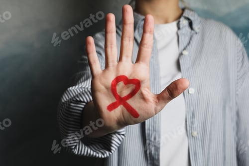 Preview: AIDS awareness sign on male hand against blue background, copy space