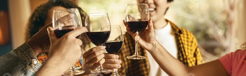 Preview: Close up of happy friends drinking wine and enjoying time together at holiday party at