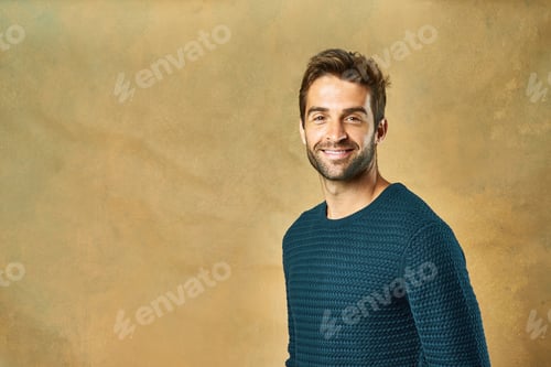 Preview: Studio shot of a handsome young man posing against a golden background