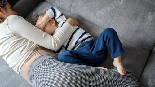 Preview: Mother breastfeeds her baby son on the sofa, surrounded by warmth and comfort