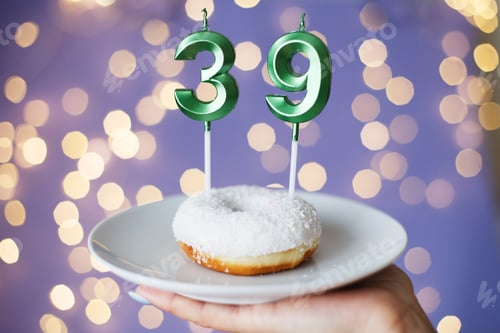 Preview: woman holding a cake with the number 39 candles on festive blurred bokeh background