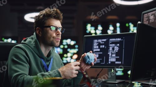 Preview: Pensive IT man working computer in late data center closeup. Coder guy creating