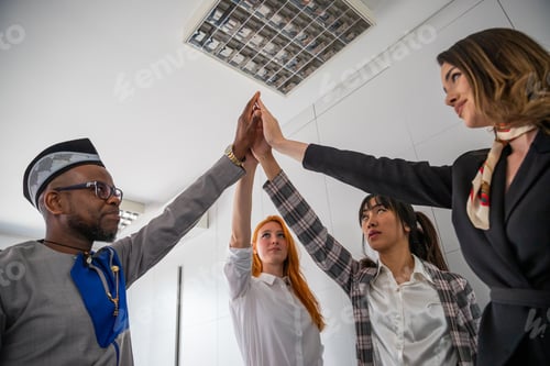 Preview: Multi ethnic group of business people join hands up, agreement found