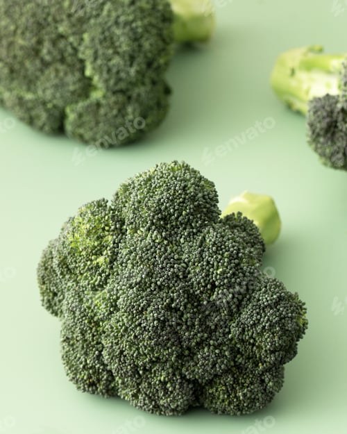 Preview: Fresh raw whole broccoli on a green background. Vegetarianism, healthy eating. Copy space