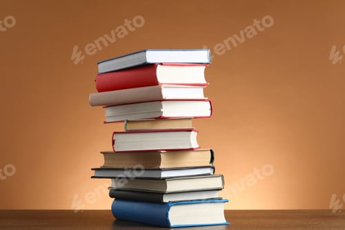 Preview: Stack of many books on wooden table against light brown background