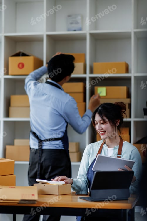 Preview: Startup small business SME. Two Young Asian business entrepreneurs using laptop computer check onlin