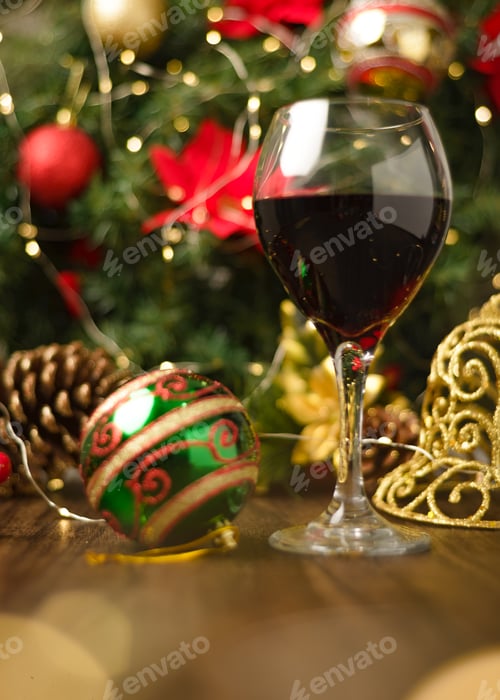 Preview: Glass of red wine on wooden table with Christmas decorations.