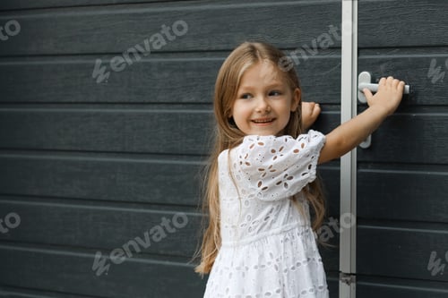 Preview: Smiling Girl Holding Door Handle Outside