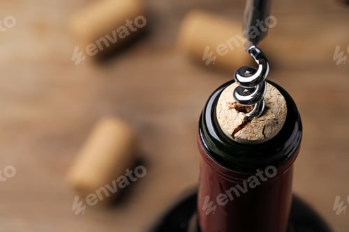 Preview: Opening wine bottle with corkscrew on table, closeup. Space for text