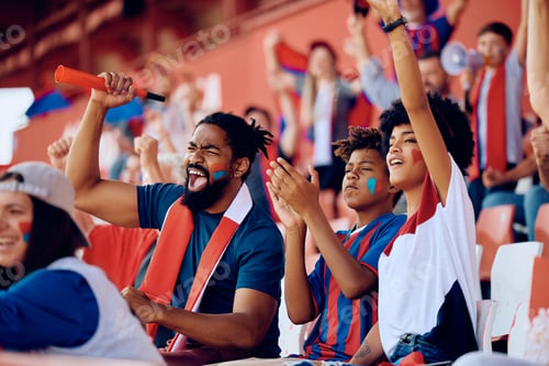 Preview: Happy black family cheering from the stands during sports match at the stadium.
